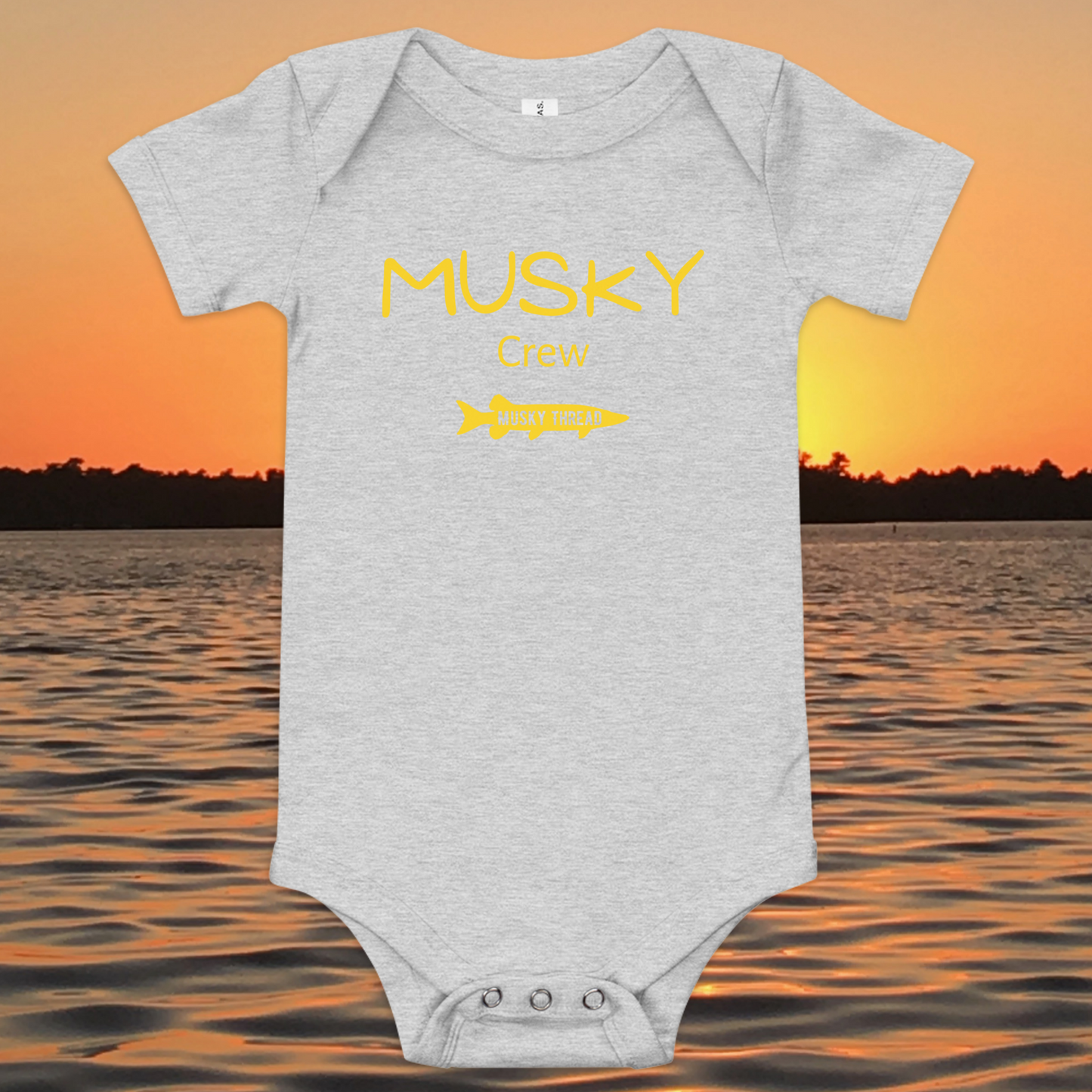 baby onesie with musky crew fishing design yellow text musky thread logo sunset lake background