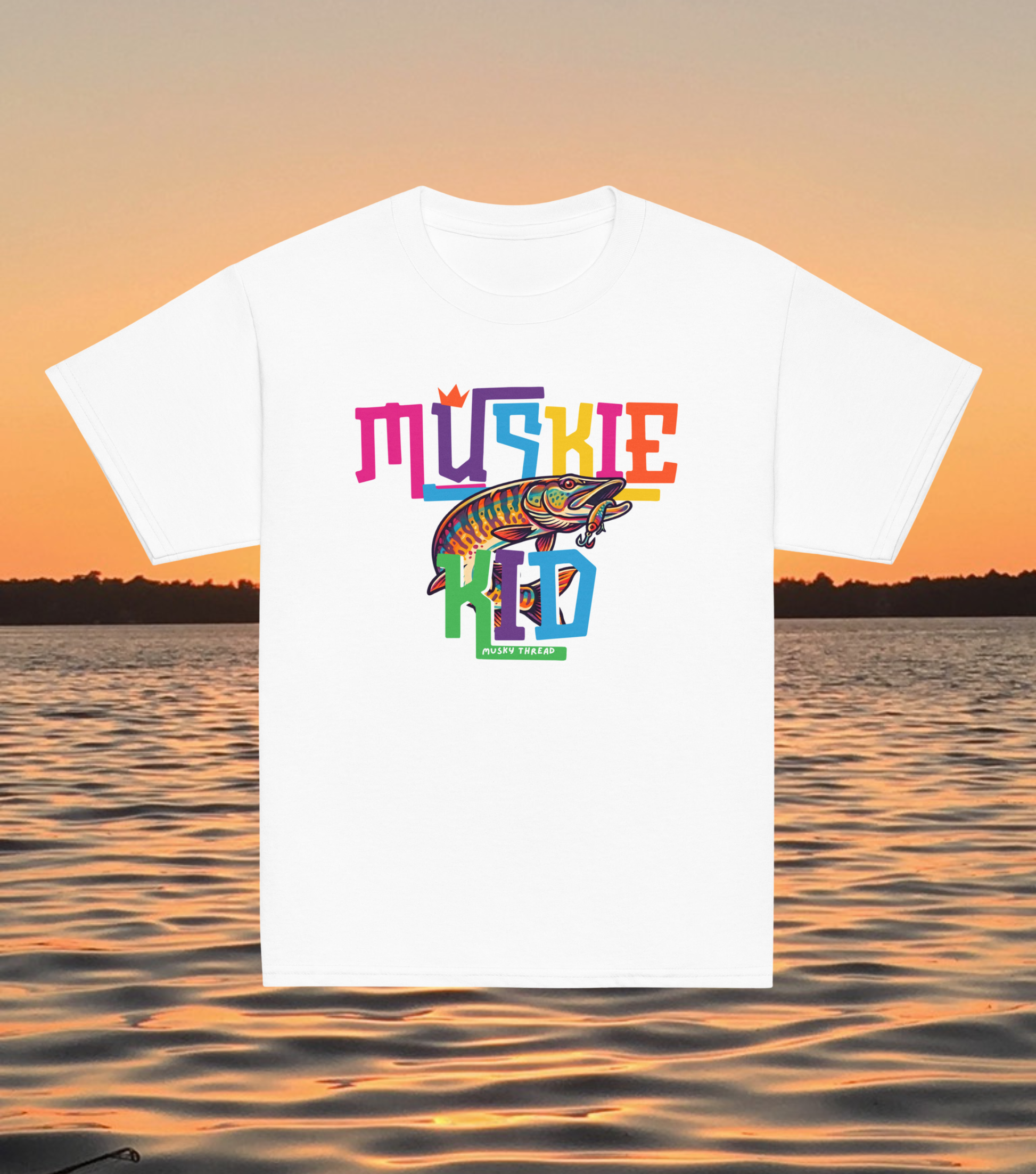 street-style youth graphic t-shirt with colorful hand-lettered Muskie Kid design featuring an illustrated musky fish and crown, displayed against a lake sunset background