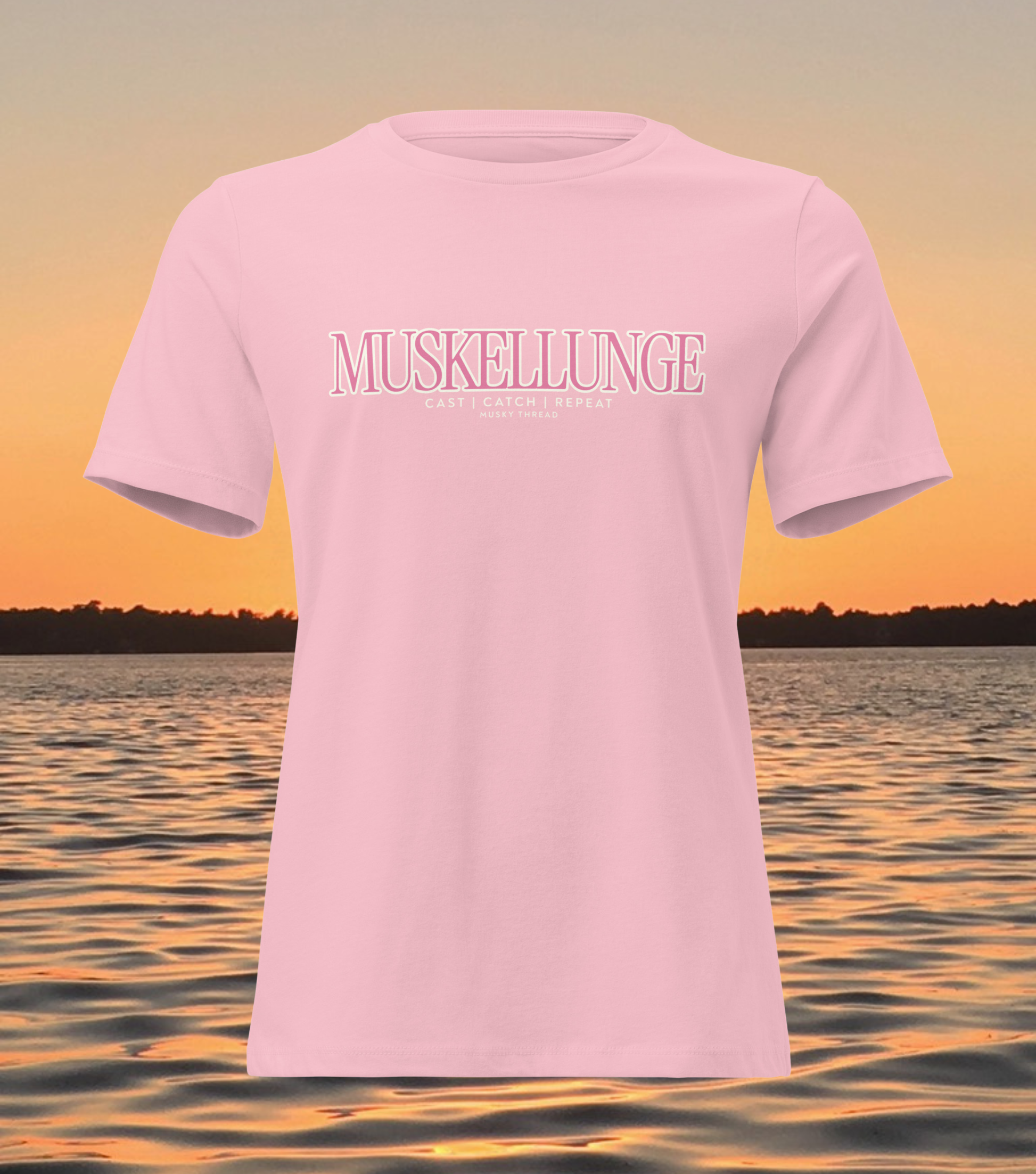 women's t-shirt with pink and white Muskellunge Cast Catch Repeat fishing design, lake sunset background