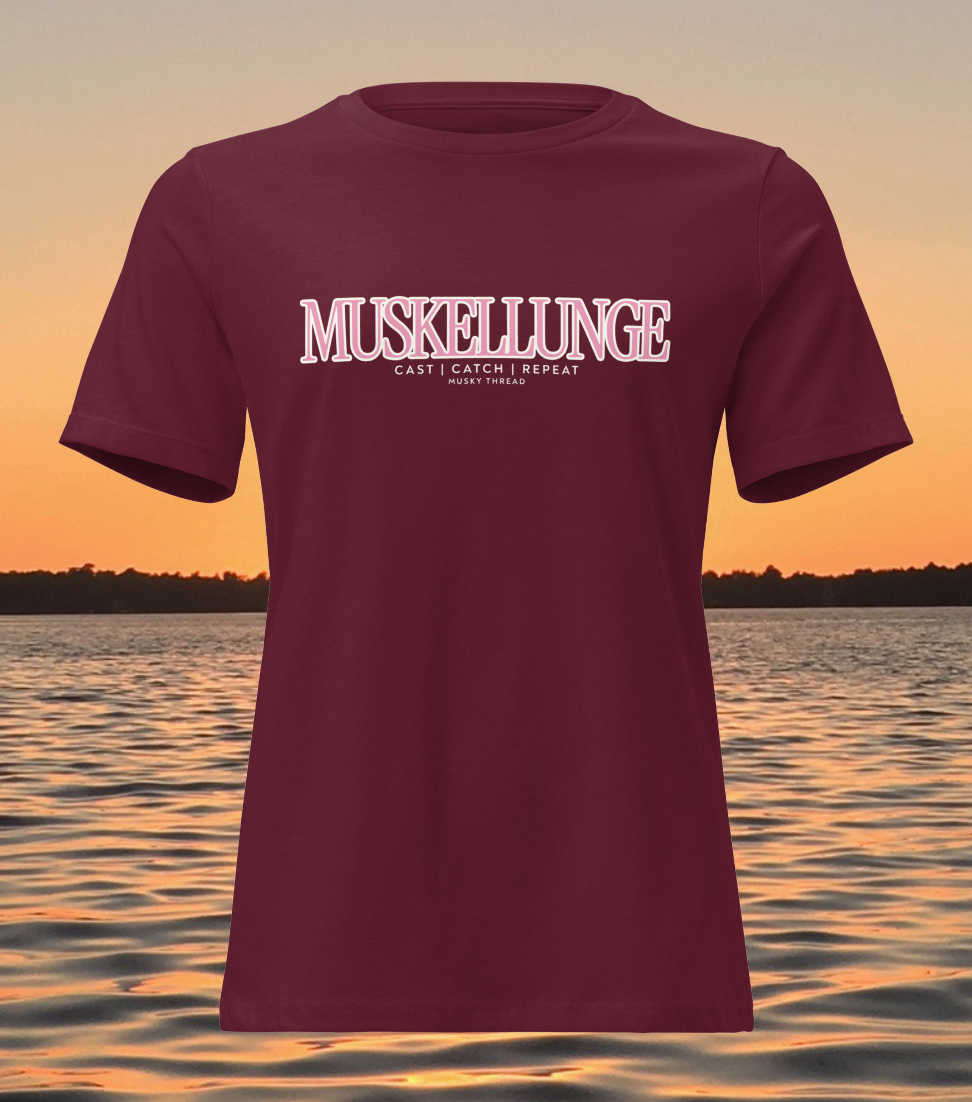 women's t-shirt with pink and white Muskellunge Cast Catch Repeat fishing design, lake sunset background