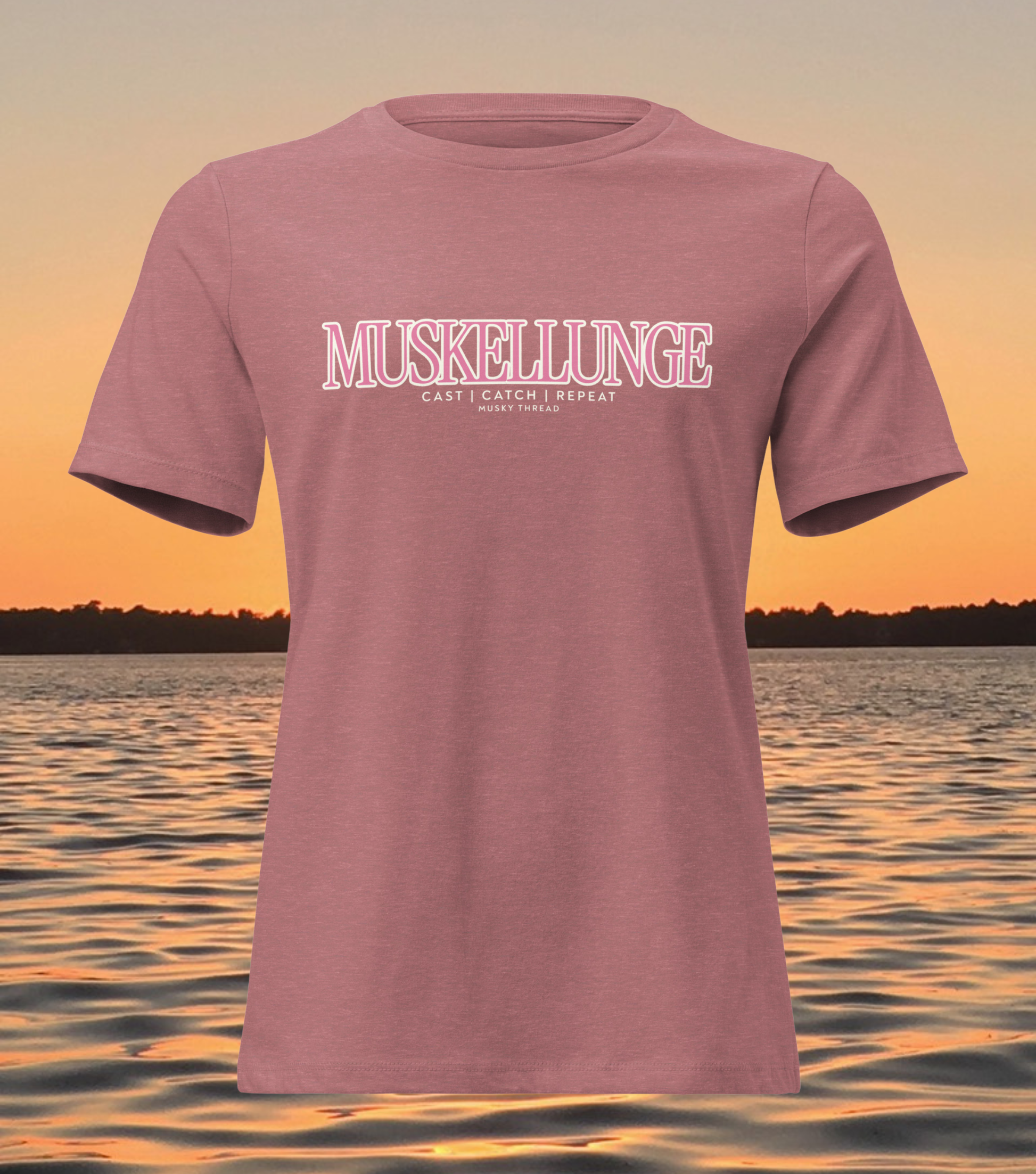 women's t-shirt with pink and white Muskellunge Cast Catch Repeat fishing design, lake sunset background