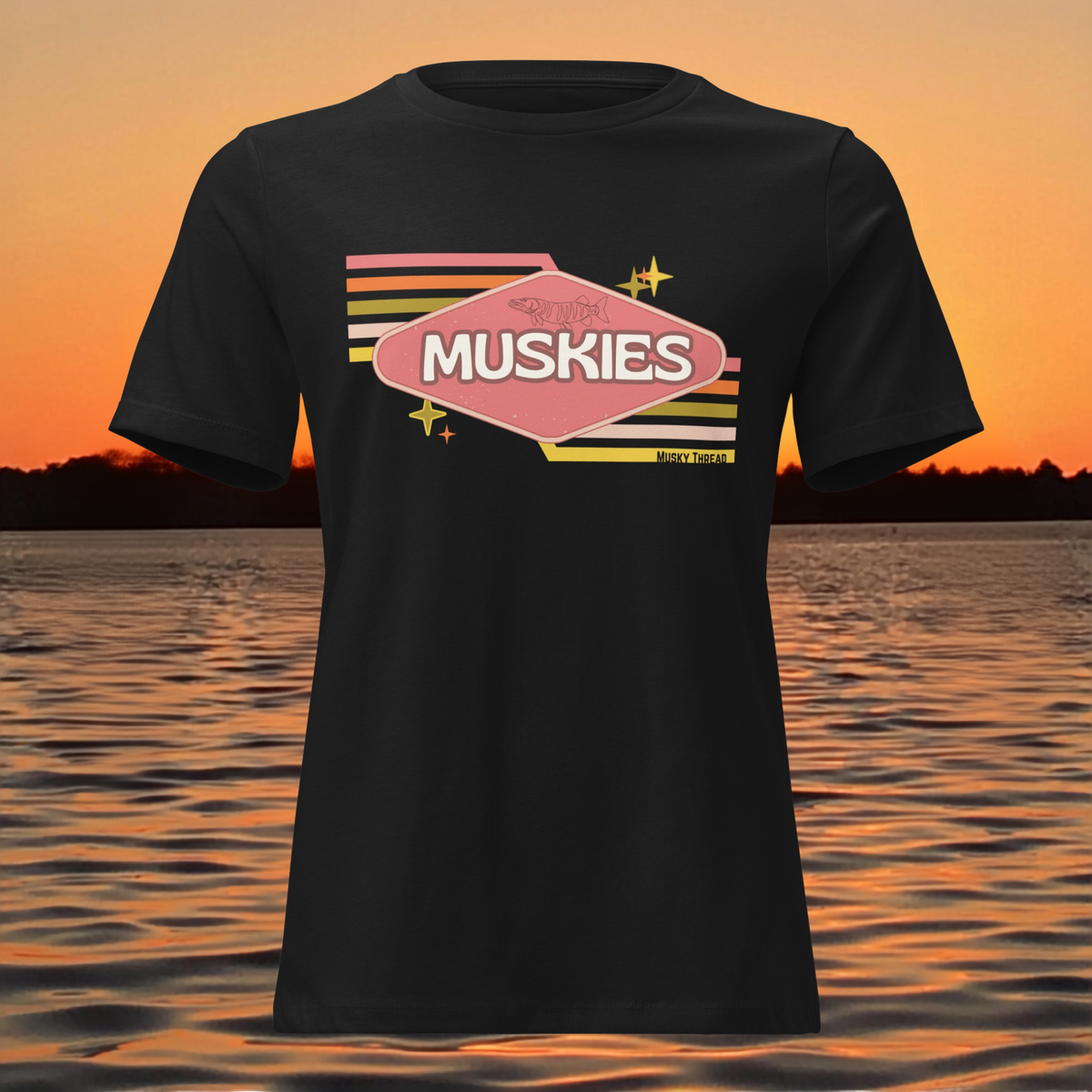 Retro Muskie Sign t-shirt featuring vintage pink and yellow badge graphic with musky fish illustration, lake sunset background
