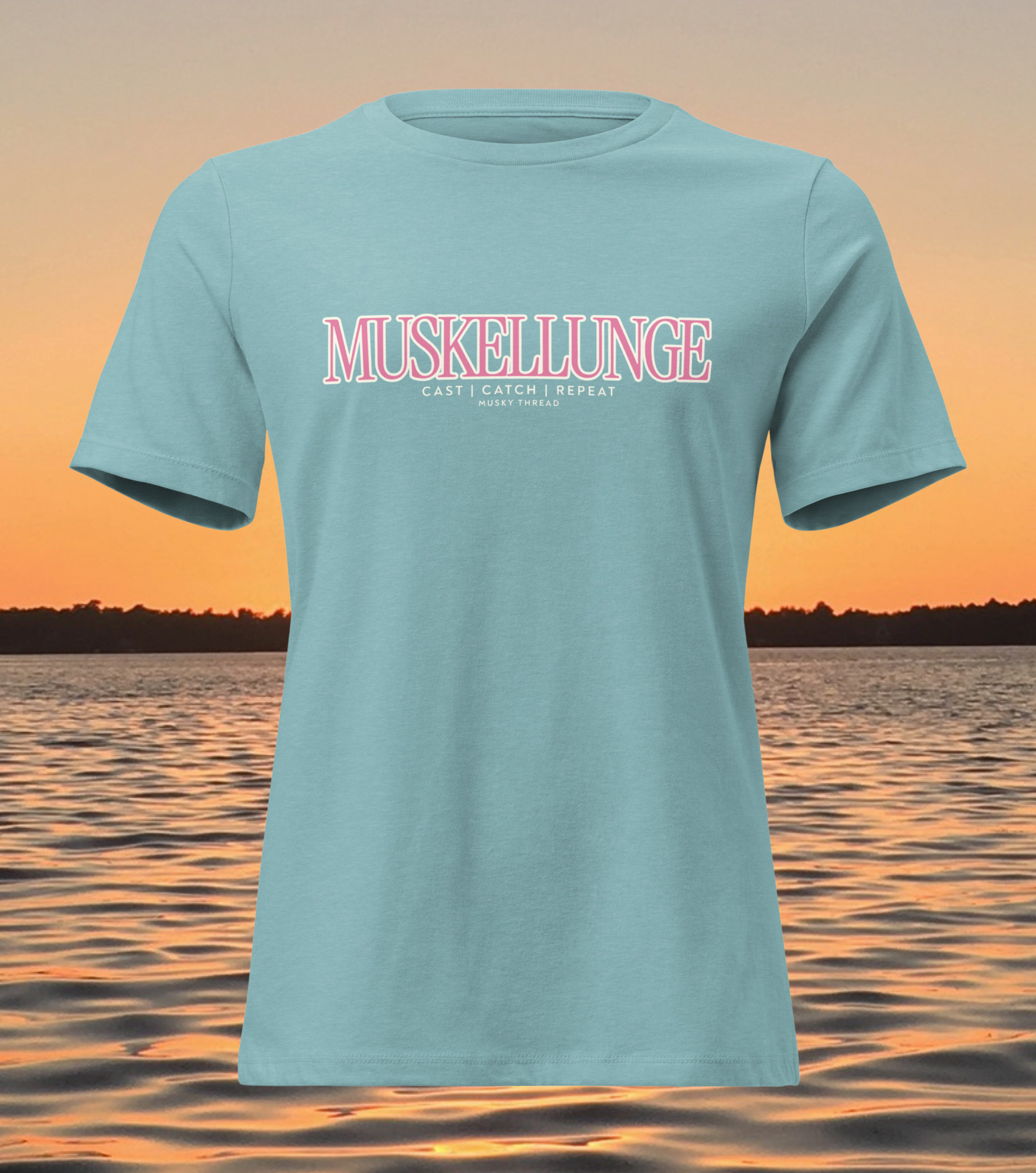 women's t-shirt with pink and white Muskellunge Cast Catch Repeat fishing design, lake sunset background