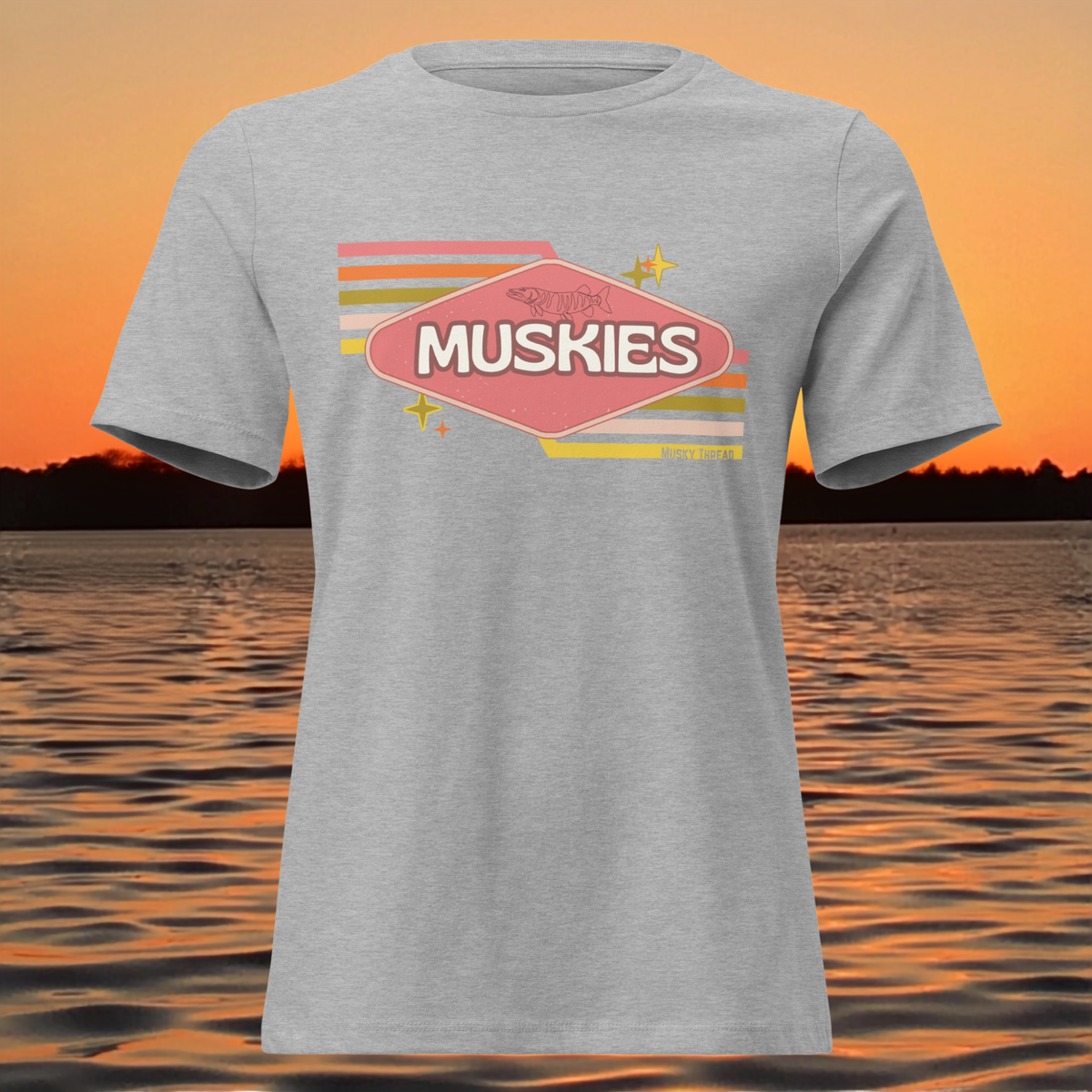 Retro Muskie Sign t-shirt featuring vintage pink and yellow badge graphic with musky fish illustration, lake sunset background