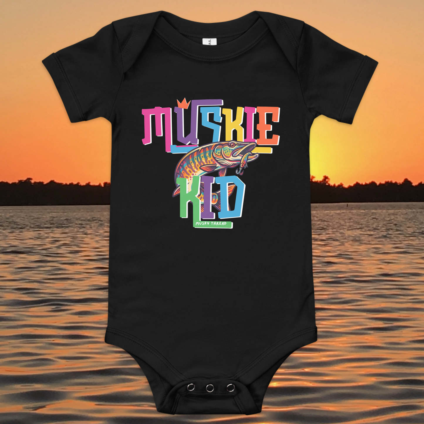 Baby short-sleeve onesie with colorful Muskie Kid street-design graphic featuring a jumping musky fish