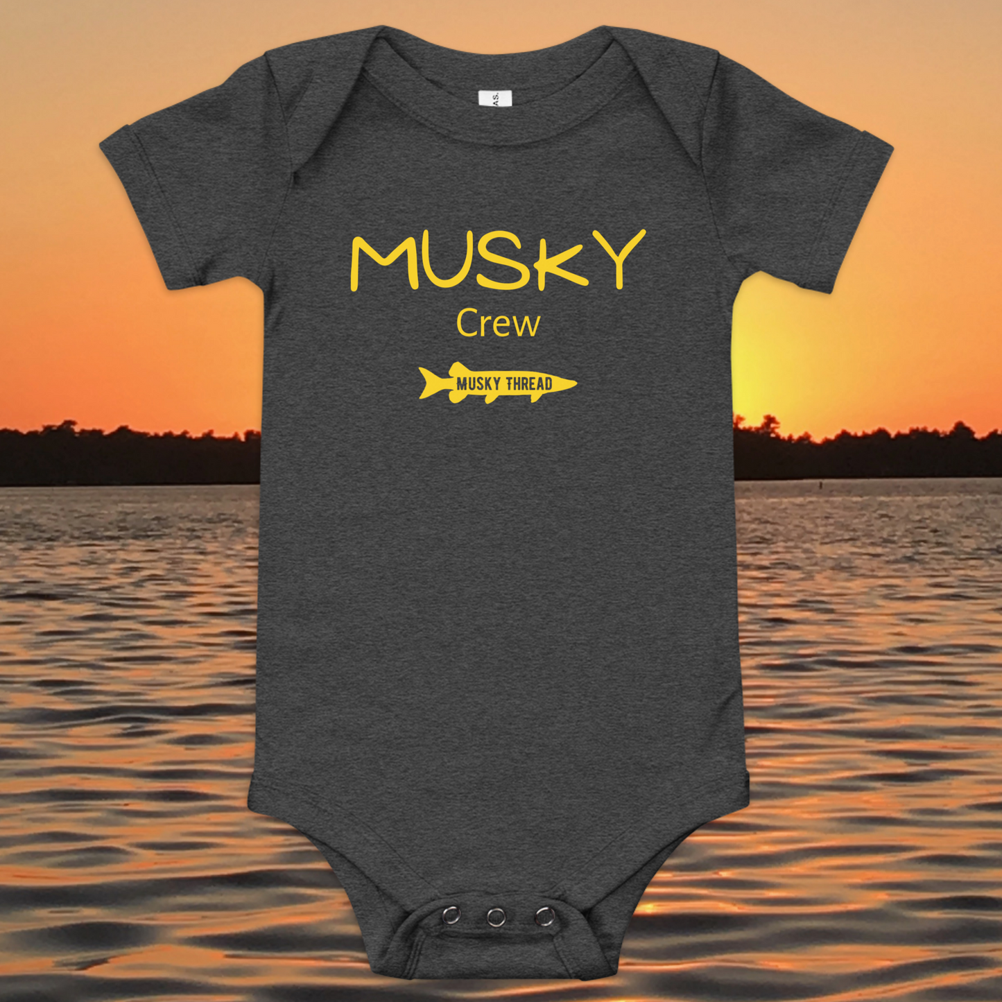 baby onesie with musky crew fishing design yellow text musky thread logo sunset lake background