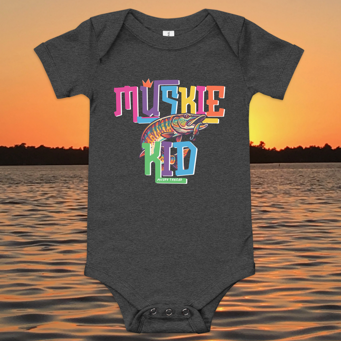 Baby short-sleeve onesie with colorful Muskie Kid street-design graphic featuring a jumping musky fish