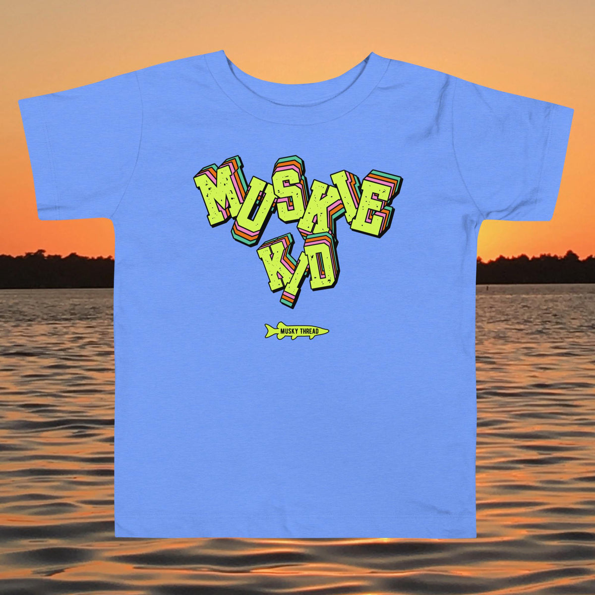 toddler t-shirt with neon green, pink, and teal "Muskie Kid" retro graphic and Musky Thread fish logo, shown against a lake sunset background
