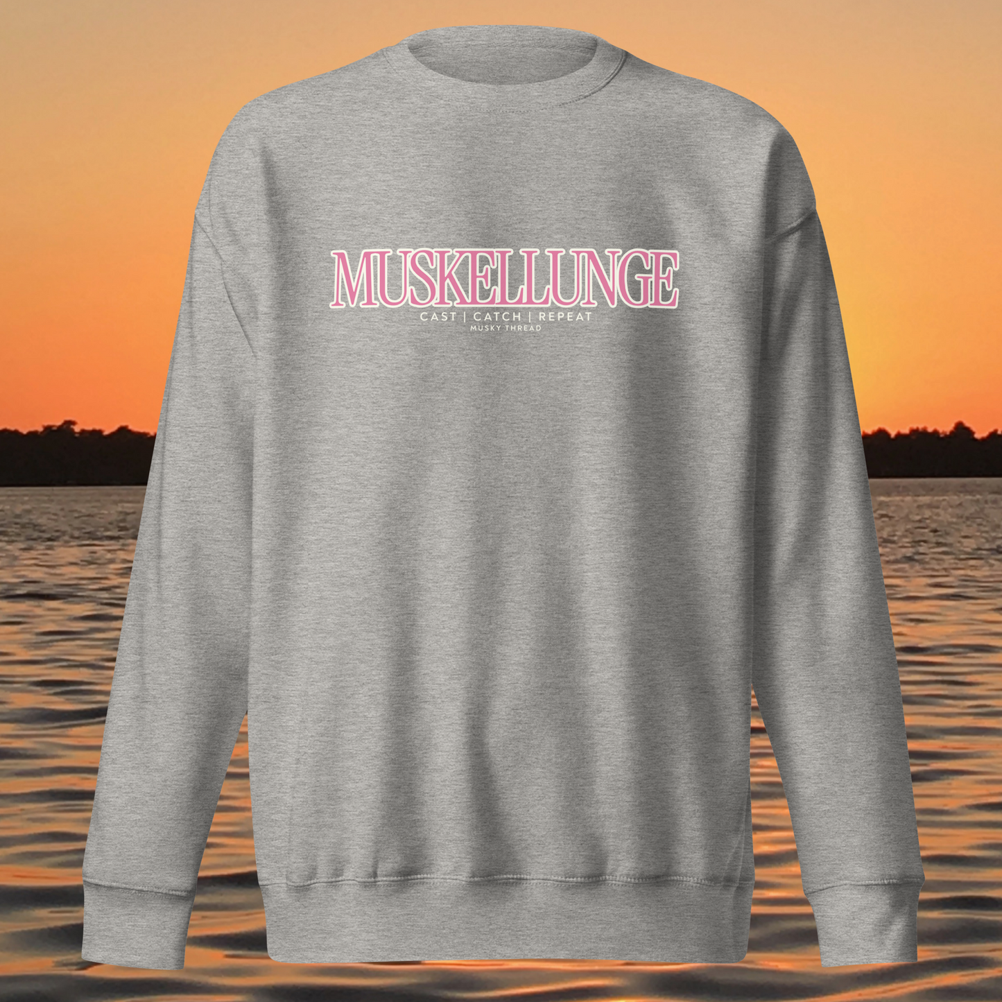 Muskellunge Cast Catch Repeat sweatshirt with pink lettering, lake sunset background