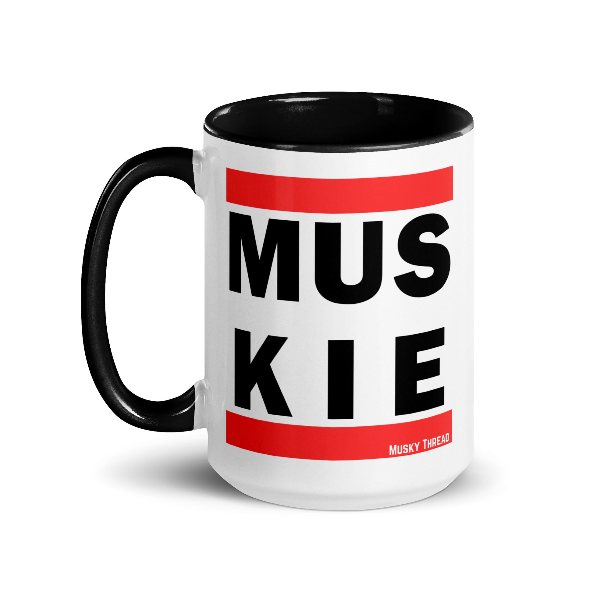 White ceramic 15oz coffee mug with black handle and interior, featuring bold retro hip-hop style MUSKIE block lettering in black text with red bars, by Musky Thread