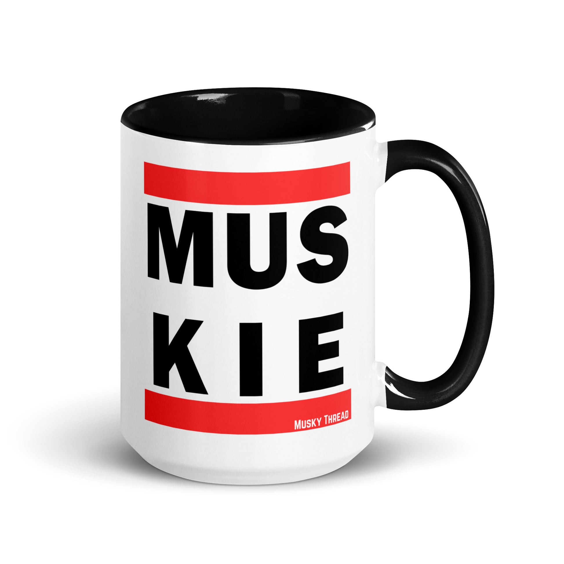 White ceramic 15oz coffee mug with black handle and interior, featuring bold retro hip-hop style MUSKIE block lettering in black text with red bars, by Musky Thread
